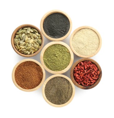 Farklı süper yiyecek tozları, kabak tohumları ve goji üzümleri beyaz kaselerde izole edilmiş, üst manzara