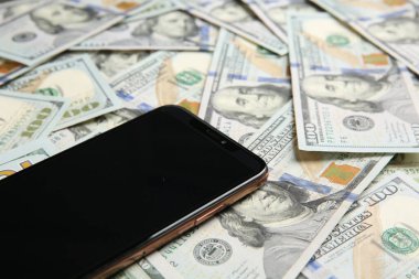 Dolar banknotları üzerinde modern akıllı telefon, yakın çekim görüntüsü