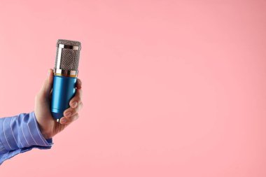 Pembe arka planda mikrofonu olan kadın, yakın plan. Metin için boşluk