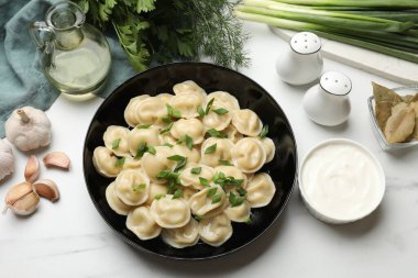 Hafif masada servis edilen yeşil soğanlı leziz pelmeni.