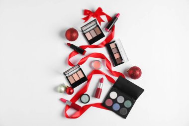 Beyaz arka planda makyaj ürünleri ve dekorla yapılmış Noel ağacı şekli