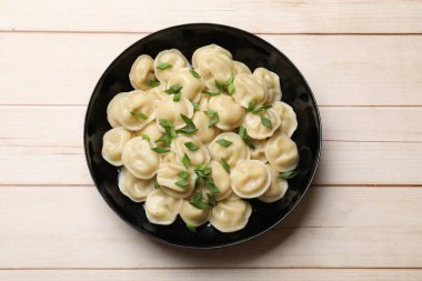 Tahta masada yeşil soğanlı leziz pelmeni.