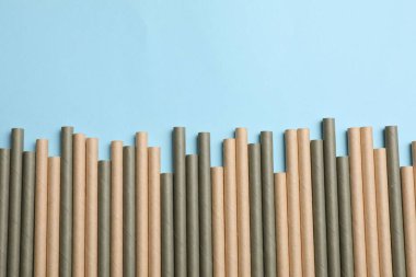 Açık mavi arka planda bambu pipetleri, üst manzara. Metin için boşluk