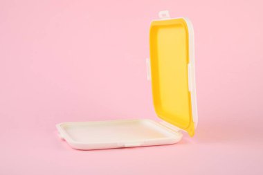 Açık pembe arka planda boş sandviç kutusu