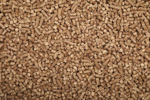 Wood pellet cat litter as background, top view