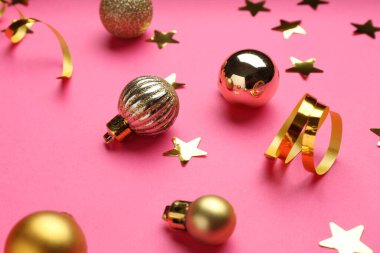Konfeti ve Noel topları pembe arka planda, yakın plan