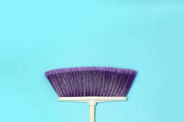 Açık mavi arkaplanda bir temizlik süpürgesi, üst görünüm