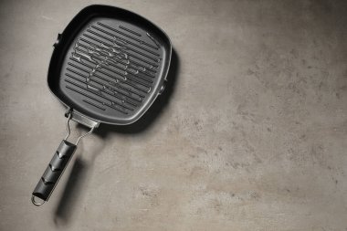 Gri desenli masa üzerinde yağlı tava, üst manzara. Metin için boşluk