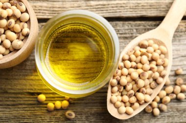 Ahşap masa üzerinde pişirme yağı ve soya fasulyesi, düz yatıyordu