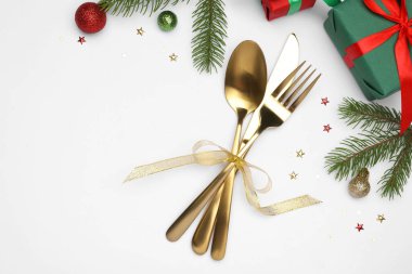 Tabak, çatal bıçak takımı ve beyaz arka planda şenlikli Noel sofrası, düz yatış