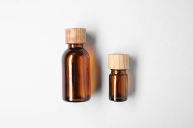 Beyaz arka planda şişelerde gerekli yağlar, üst görünüm