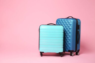 Pembe arkaplanda iki yeni bavul, metin için boşluk