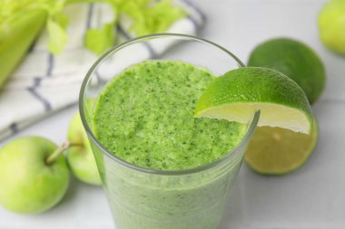 Lezzetli yeşil smoothie limon ve elmalar ışık masasında, yakın plan