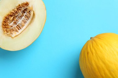 Açık mavi arka planda taze kavunun yarısı düz uzanıyordu.