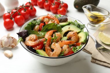 Lezzetli karides salatası ve malzemeler beyaz masada, yakın plan.