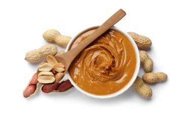 Lezzetli fıstık ezmesi kasede, kaşıkta ve yerfıstığı beyaza izole edilmiş.