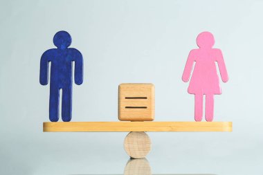 Cinsiyet eşitliği kavramı. Erkek ve kadın figürleri hafif arkaplana karşı ölçekte