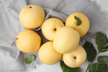 Delicious fresh apple pears and green leaves on white table, top view clipart