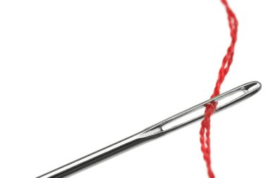 Kırmızı iplikli dikiş iğnesi beyaza izole edilmiş, yakın plan.