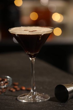 Masada cam içinde nefis espresso martini bulanık ışıklara karşı, yakın plan.