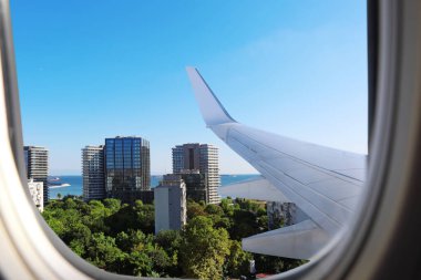 Airplane taking off or landing, view on city from window clipart