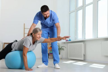 Rehabilitasyon merkezinde kıdemli bir hastayla çalışan fizyoterapist.
