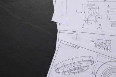 Gri desenli masa üzerine farklı mühendislik çizimleri. Metin için boşluk