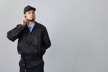 Gri arka planda kulaklığı olan üniformalı güvenlik görevlisi, metin için boşluk