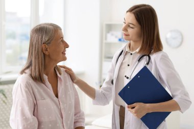 Hastanedeki kıdemli hastayı destekleyen gülümseyen sağlık görevlisi