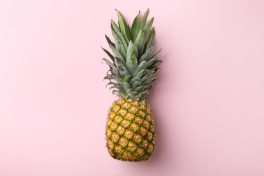 Pembe arka planda taze, olgun bir ananas.
