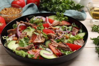 Lezzetli taze ton balığı salatası ve ahşap masadaki malzemeler, yakın plan.