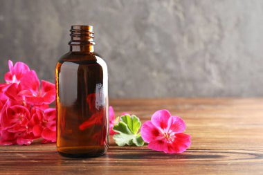 Sardunya yağı şişede ve güzel çiçekler ahşap masada.