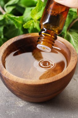 Kadın, gri masada yağını kaseye damlatıyor, yakın plan.