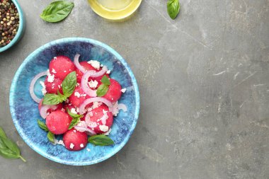 Feta peynirli nefis karpuz salatası, nane ve soğan kasede gri desenli masa, düz yatak. Metin için boşluk