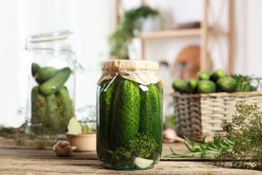 Kavanozda salatalık turşusu ve ahşap masada malzemeler, yakın plan.