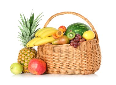 Hasır sepetteki birçok farklı taze meyve beyaza izole edilmiş.