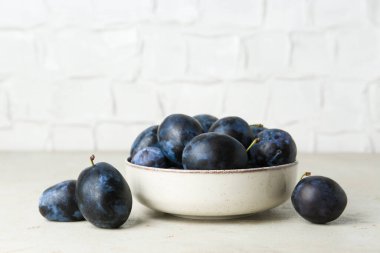 Açık dokulu masada olgun erikler.