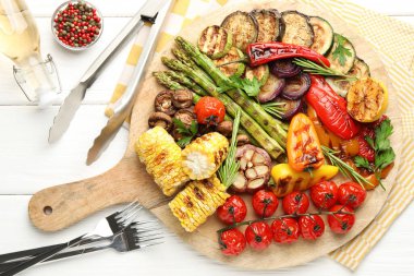 Beyaz ahşap masada servis edilen nefis ızgara sebzeler.