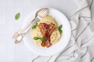 Carbonara makarnası beyaz fayanslarla servis edilir.