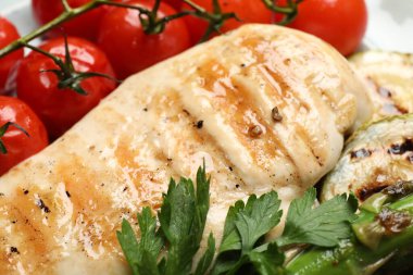 Lezzetli ızgara sebzeler ve tabakta tavuk göğsü, yakın plan.