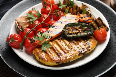Lezzetli ızgara sebzeler ve tavuk göğsü masada, yakın plan.