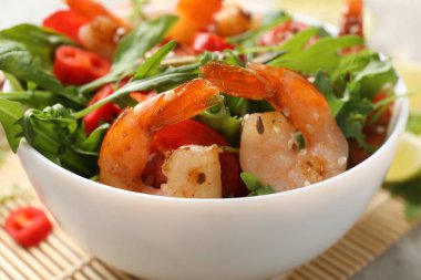 Gri masada sebzeli lezzetli karides salatası, yakın plan.