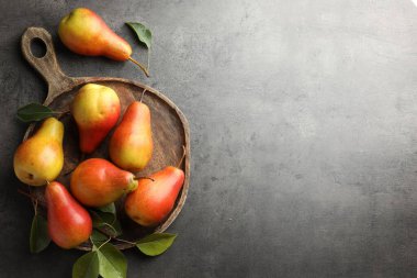 Gri masa üzerinde olgun sulu armutlar, düz uzanmış. Metin için boşluk