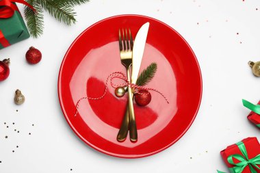 Tabak, çatal bıçak takımı ve beyaz arka planda şenlikli Noel sofrası, düz yatış