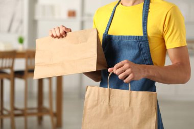 Kapalı mekanda kese kağıdıyla fast food işçisi, yakın plan.