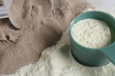 Protein tozu ve kepçeleri yığını, yakın plan.
