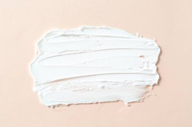 Bej arka planda kozmetik ürünlerin karışımı, üst görünüm