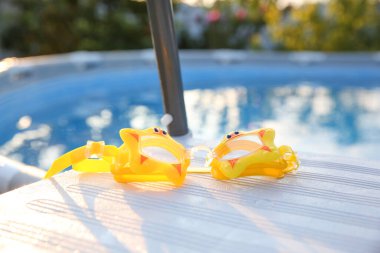 Merdivendeki çocuklar için sarı yüzme gözlükleri, yakın plan.