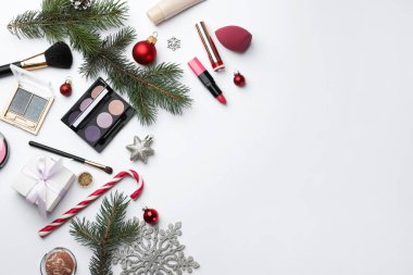 Farklı dekoratif kozmetik ürünleri ve beyaz arka planda Noel dekorasyonu. Metin için boşluk