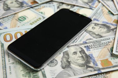 Dolar banknotları üzerinde modern akıllı telefon, yakın çekim görüntüsü